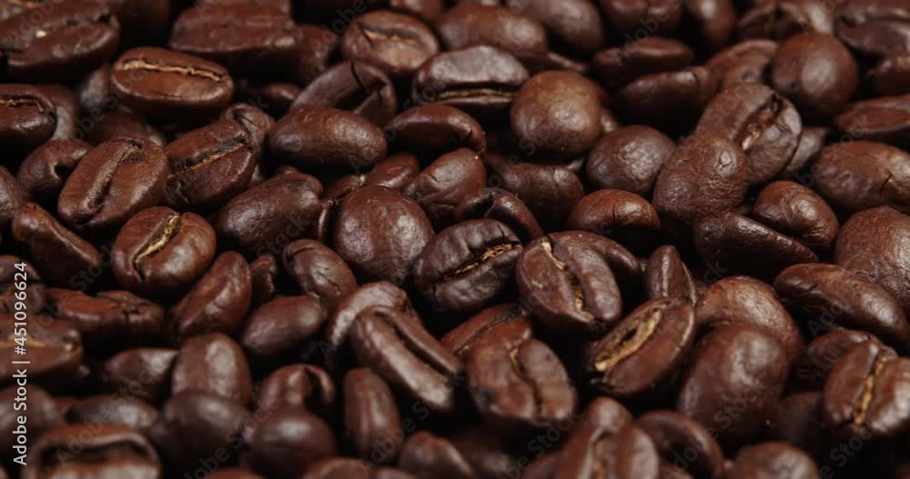 Roasted coffee beans dolly shot. Aromatic coffee beans move slowly. Slide slow motion close-up of whole roasted coffee beans. Roasted coffee beans dolly shot. Aromatic coffee beans move slowly. Slide slow motion close-up of whole roasted coffee beans.