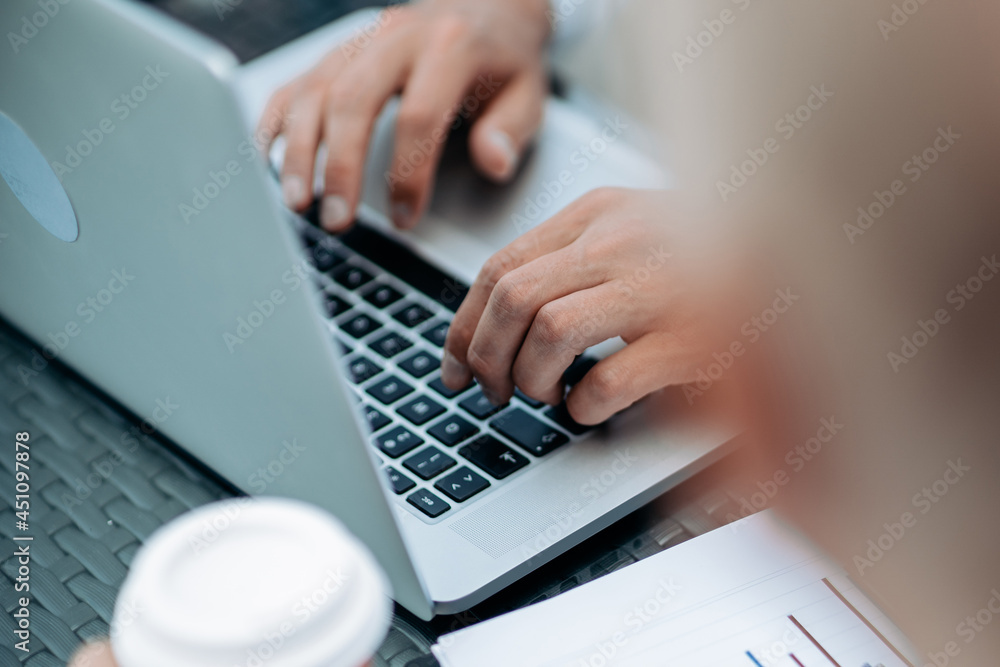 businessman works on a laptop with financial data.
