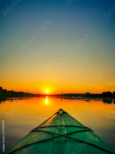 View of front of kayak, floating on the river at summer sunset © Audrius