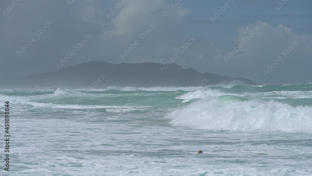 Surfer riding and turning with spray on blue ocean wave, surfing ocean lifestyle, extreme sports. Big waves with white foam in Hawaii. Pacific Ocean