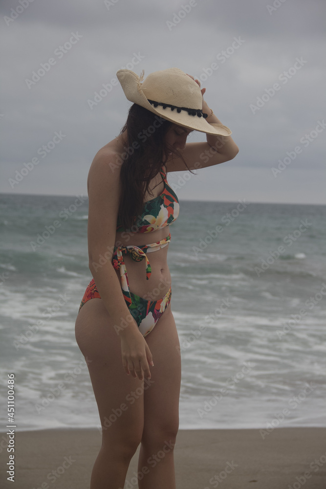 Young girl on the beach with hat