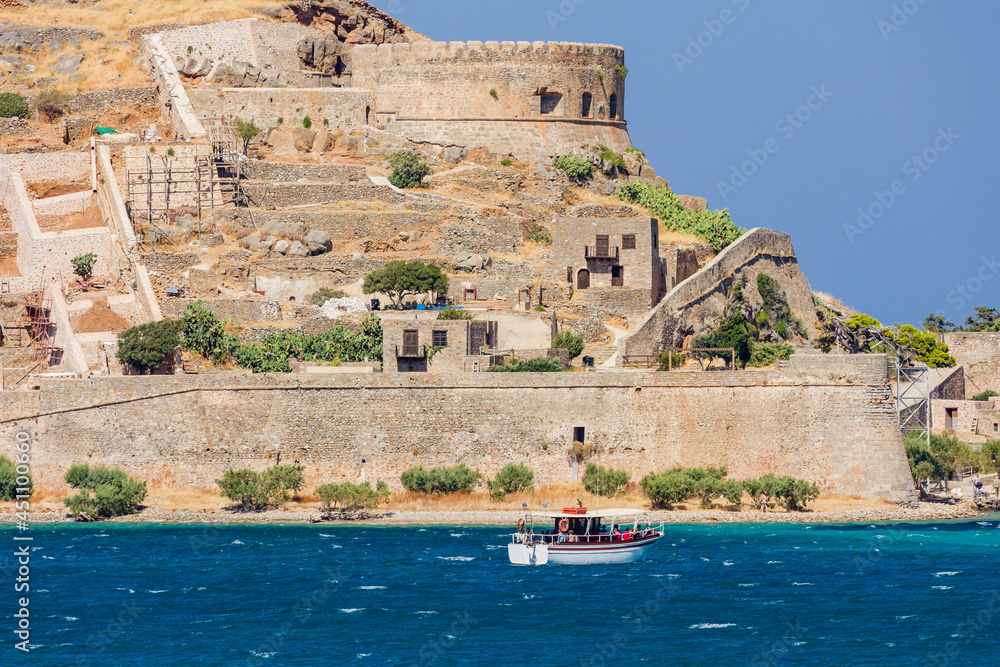 Tourist boats in front of the former leper colony on the island of Spingalonga, Crete, Greece