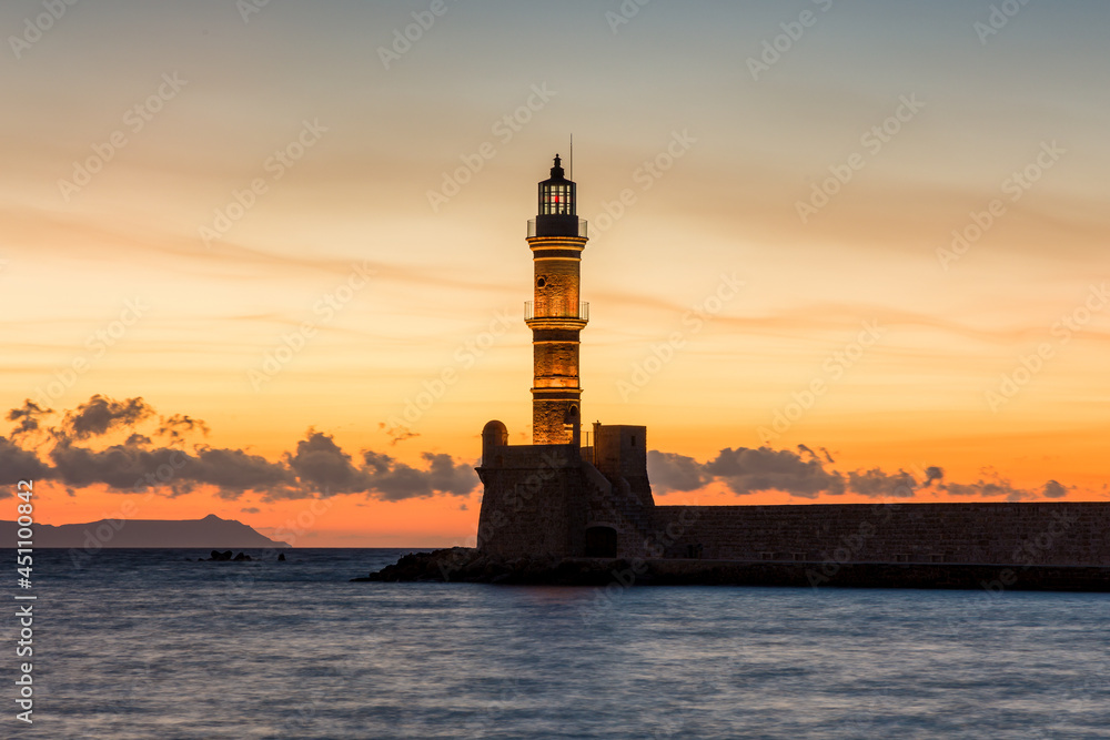 Ancient Venetian lighthouse guarding the old port of Chania, Greece at Sunset
