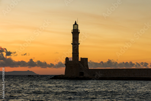 Sunset behind an ancient stone lighthouse (Veneitian Port, Chania, Crete)