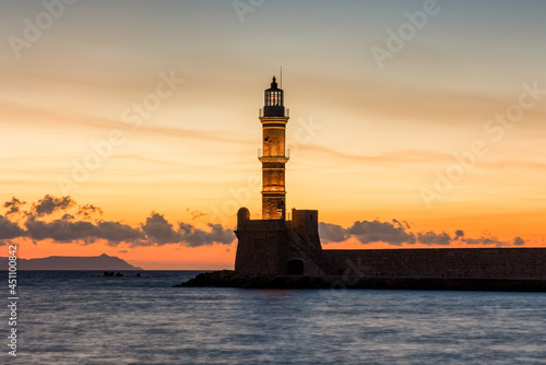 Ancient Venetian lighthouse guarding the old port of Chania, Greece at Sunset