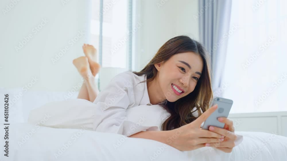 Asian attractive woman use mobile phone chat on bed at home in morning Asian attractive woman use mobile phone chat on bed at home in morning