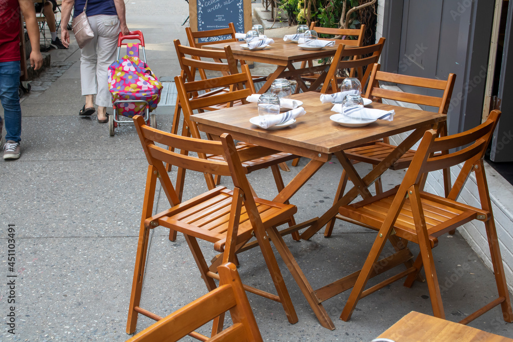 open tables at a NY restaurant dining alfresco people walking sidewalk