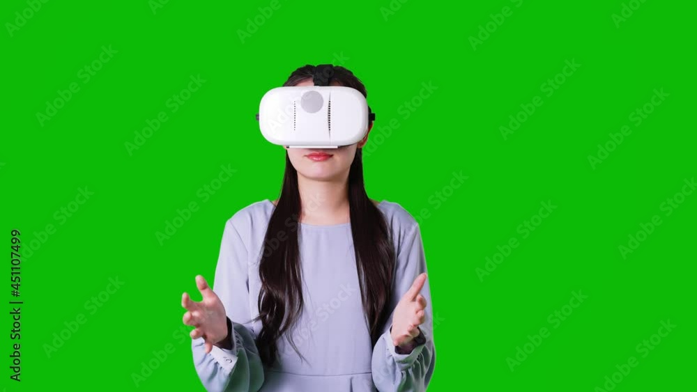 VRゴーグルを装着した女性　クロマキー合成用グリーンバック 