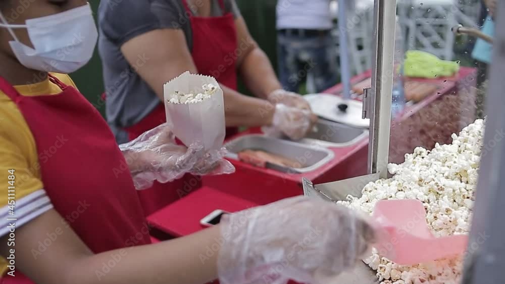 joven vendedora preparando bolsas de palomitas de maíz frescas