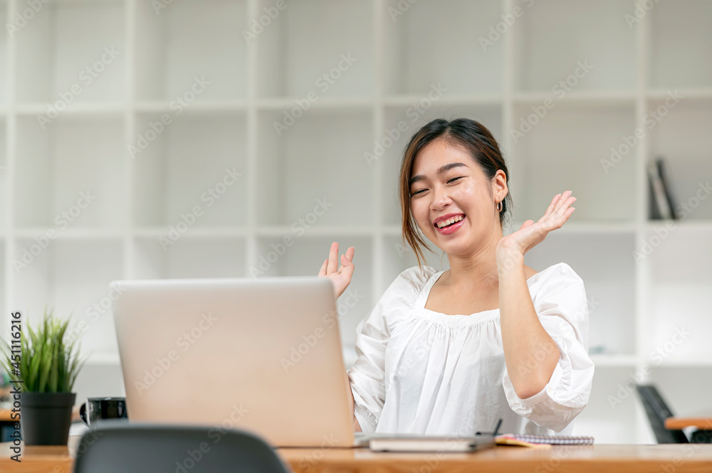 Young Asian woman using laptop video call talking with couple while working from home at living room. Young Asian woman using laptop video call talking with couple while working from home at living room.