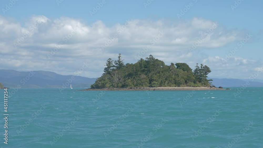 Green Forest At The Small Island Amidst The Blue Ocean At Whitsundays In Australian State Of Queensland. wide shot Green Forest At The Small Island Amidst The Blue Ocean At Whitsundays In Australian State Of Queensland. wide shot