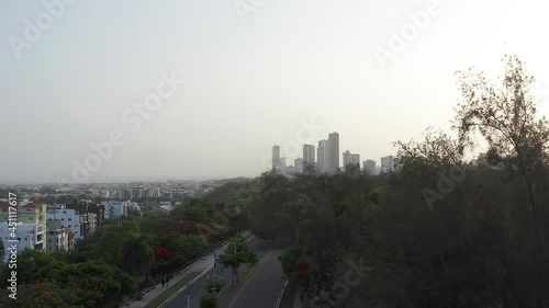 Drone flying over pedestrian and cycle path at Mirador Sur Park with skyscrapers in background, Santo Domingo photo