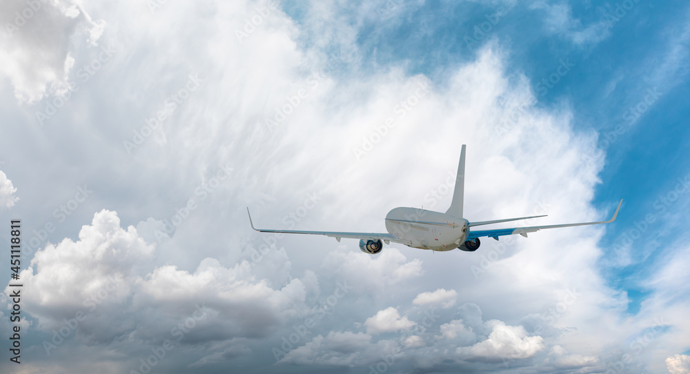 Obraz premium White passenger airplane over the stormy clouds - Travel by air transport