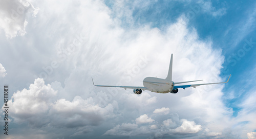 White passenger airplane over the  stormy clouds  - Travel by air transport