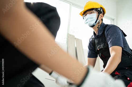 Construction worker installs laminate board on floor to renovate house