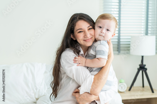 Portrait of Caucasian happy family smiling, look at camera in bedroom