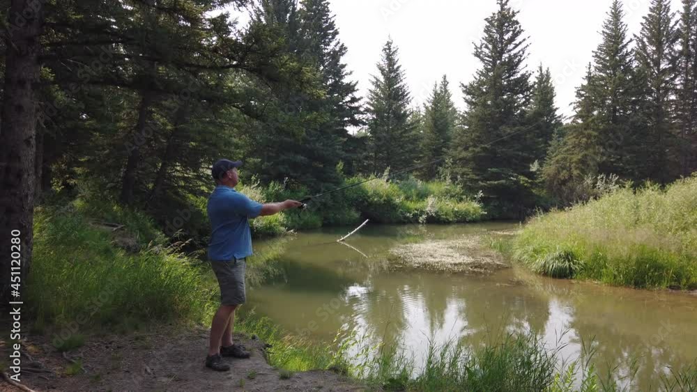 Caucasian Man Throwing His Fishing Rod On Lake In Forest At Summer. - Static Shot Caucasian Man Throwing His Fishing Rod On Lake In Forest At Summer. - Static Shot