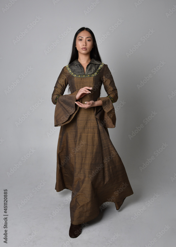Fototapeta premium Full length portrait of beautiful young asian woman with long hair wearing medieval fantasy gown costume. Graceful standing posing isolated on studio background.