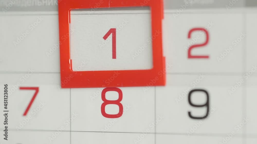 Close-up of a woman's finger moves the date pointer on the calendar Close-up of a woman's finger moves the date pointer on the calendar