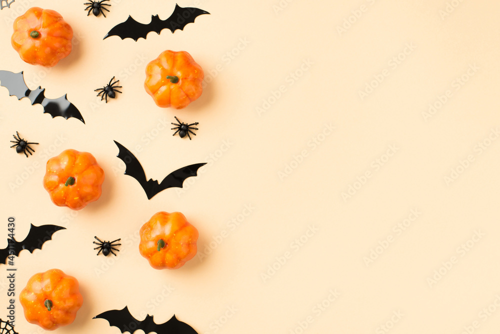 Top view photo of halloween decorations small pumpkins spiders web and bats silhouettes on isolated beige background with copyspace Top view photo of halloween decorations small pumpkins spiders web and bats silhouettes on isolated beige background with copyspace