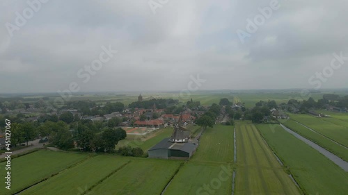 Flying towards a scaffolding windmill in a rural town in the Netherland photo