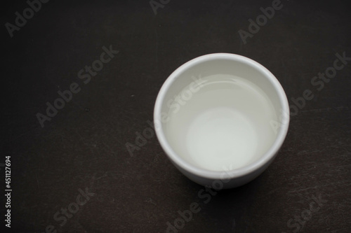 White ceramic glass on black table background.