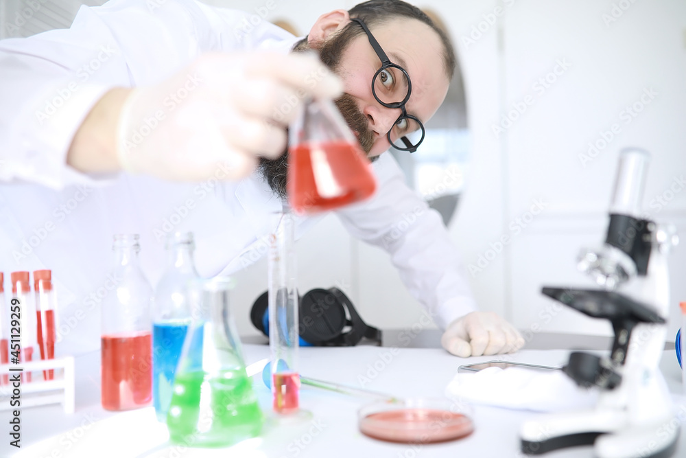 Chemist crazy. A mad scientist conducts experiments in a scientific laboratory. Performs research using a microscope. Chemist crazy. A mad scientist conducts experiments in a scientific laboratory. Performs research using a microscope.