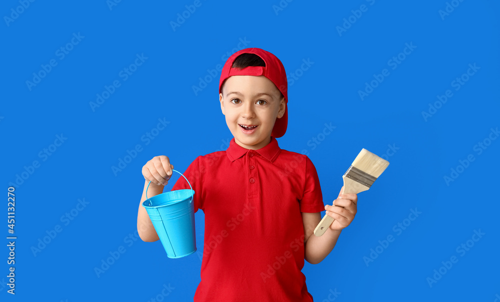 Little painter with bucket and brush on color background Little painter with bucket and brush on color background
