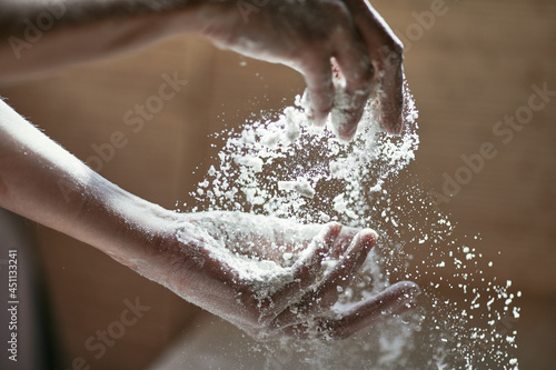 Motion picture - sifting flour by hand, women's hands close-up in backlight