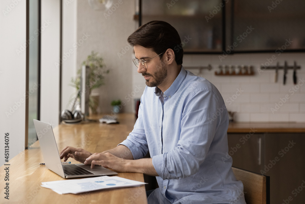 Stockfoto Serious male entrepreneur sit at bar counter in office or home  kitchen working using laptop. Telecommuting, solve business remotely due  covid quarantine, modern technology usage and connection concept | Adobe  Stock