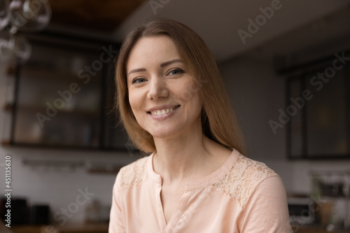 Fotografie Head shot portrait young Caucasian 35s woman sit in domestic kitchen smile looks at camera