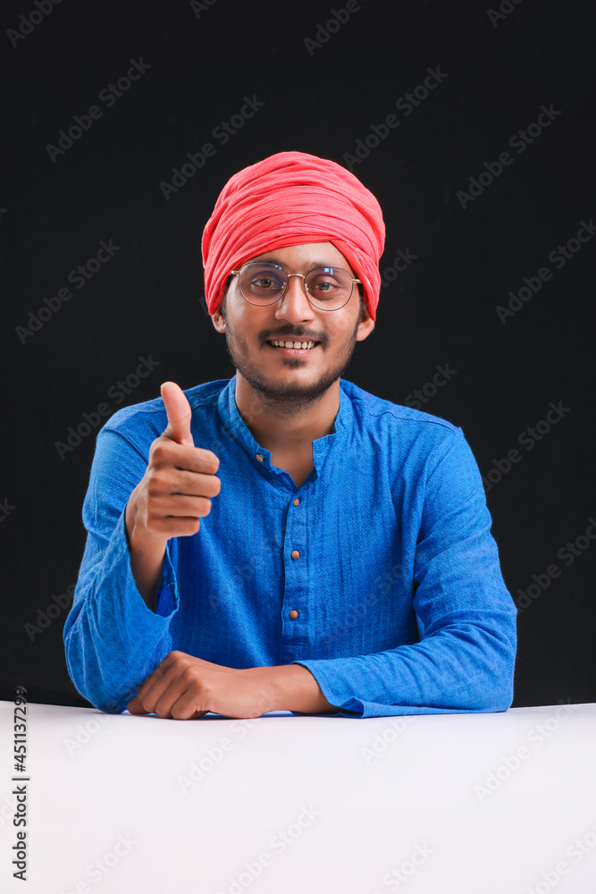 Fototapeta premium Young indian farmer giving expression on dark background.