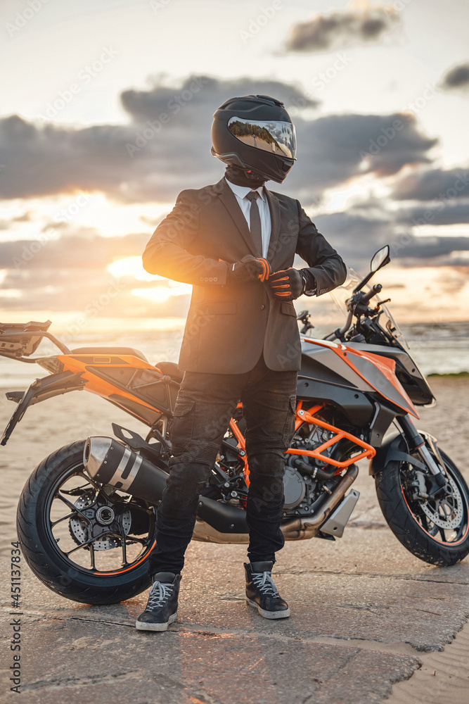 Naklejka premium Active businessman with modern sports motorbike on beach