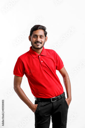 Happy Asian man in t-shirt and cap standing on white background, Delivery service concept © PRASANNAPIX