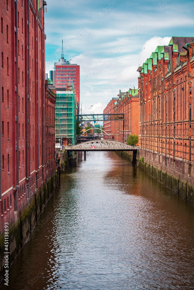 View of a canal in  Hamburg's Speicherstad district with industrial climber doing building maintenance