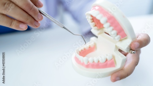 Dentist at dental clinic White healthy tooth with Dental model in oral surgeons discussing jaw x-ray on tablet  medicine healthcare oral surgery concept