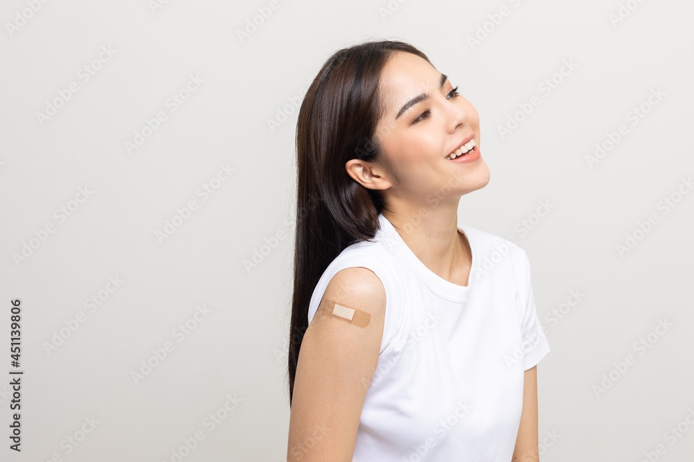 Vaccination. Young beautiful asian woman getting a vaccine protection the coronavirus. Smiling happy female showing arm with bandage after receiving vaccination. On isolated white background. Vaccination. Young beautiful asian woman getting a vaccine protection the coronavirus. Smiling happy female showing arm with bandage after receiving vaccination. On isolated white background.