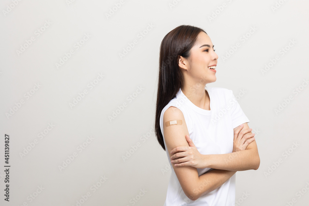 Vaccination. Young beautiful asian woman getting a vaccine protection the coronavirus. Smiling happy female showing arm with bandage after receiving vaccination. On isolated white background. Vaccination. Young beautiful asian woman getting a vaccine protection the coronavirus. Smiling happy female showing arm with bandage after receiving vaccination. On isolated white background.