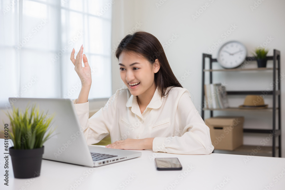 Young asian woman using laptop chatting video conference online sitting in living room at home. Business Woman looking at screen Meeting on social media live steam. Work, learning from home.