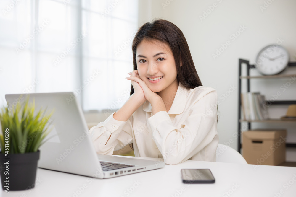Young asian beautiful business woman working with laptop sitting at home. Smiling charming happy young female doing homework meeting conference with team at home. Young asian beautiful business woman working with laptop sitting at home. Smiling charming happy young female doing homework meeting conference with team at home.