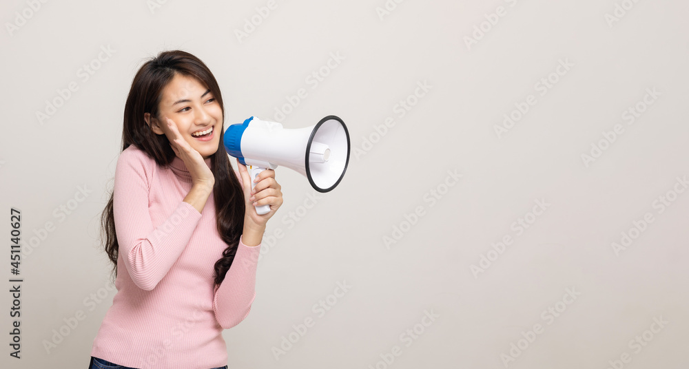 Shout out loud with megaphone. Young beautiful asian woman woman announces with a voice about promotions and advertisements for products at a discounted price. Shopping and fashion concept. Shout out loud with megaphone. Young beautiful asian woman woman announces with a voice about promotions and advertisements for products at a discounted price. Shopping and fashion concept.