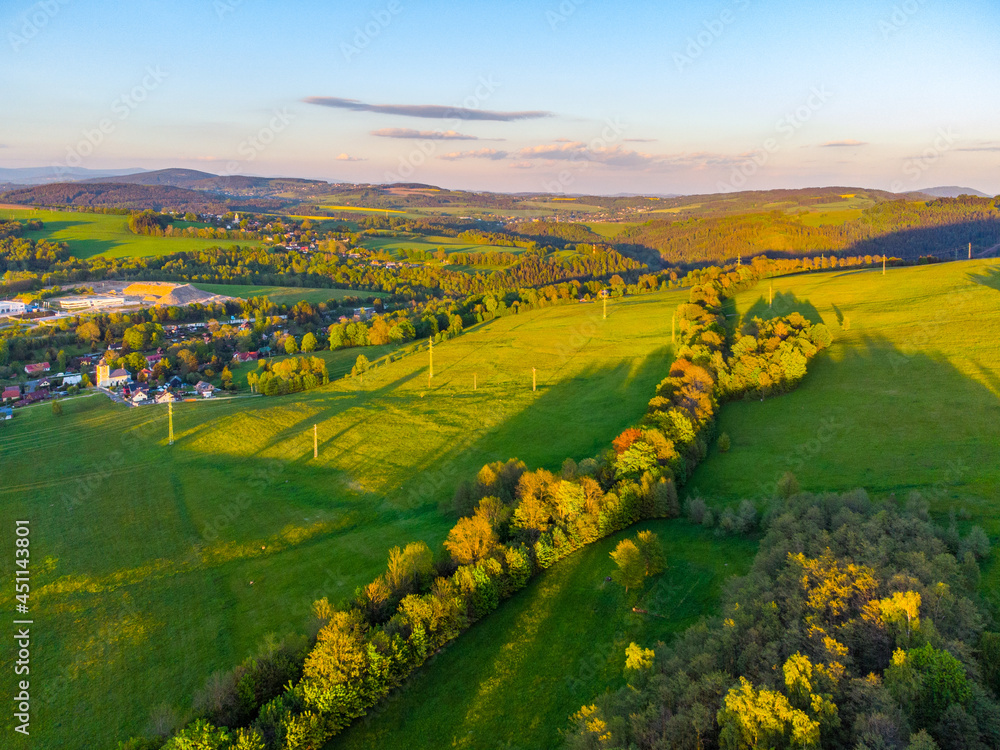 Green rural landscape of Northern Bohemia at susnet time. Aerial view from drone.