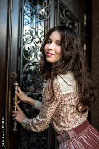 portrait of young lady wear a fashion cloth posing near old texture doors