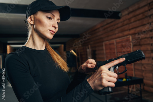 Konstfotografi Serene experienced female shooter cocking her gun
