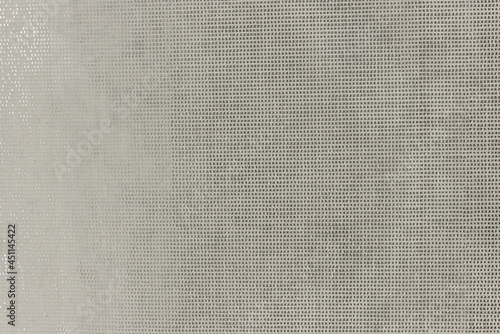 An uneven, ragged grid with small cells. Abstract rough texture with spots and stripes.