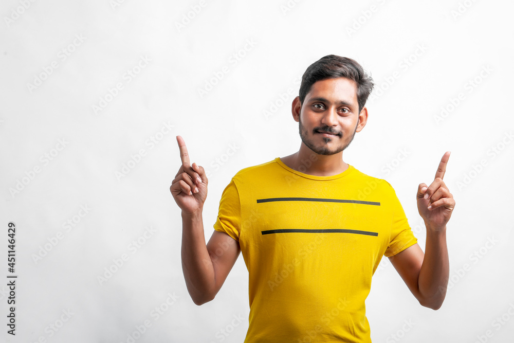 Fototapeta premium Young indian man showing direction with hand over white background.