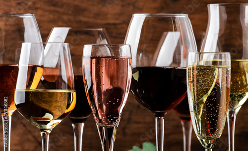 Wine tasting. Red, white, rose and champagne - still and sparkling wines sin glasses on vintage wooden table background photo