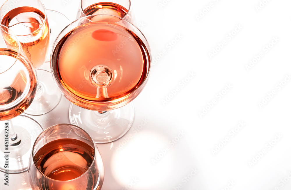 Rose wine glasses on white background. Wine tasting, top view, negative space Rose wine glasses on white background. Wine tasting, top view, negative space
