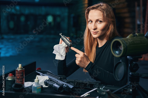 Professional female shooter cleaning her disassembled firearm photo