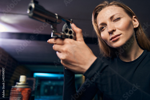 Serene lady pointing her revolver at a target